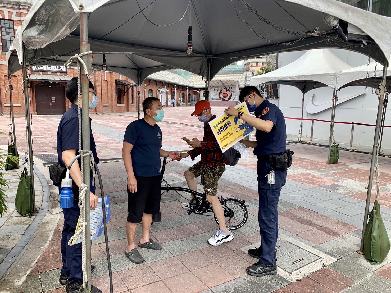 圖  臺北市保安警察大隊員警手持宣導海報，以標語提醒民眾，小心防疫期間常見的簡訊詐騙。