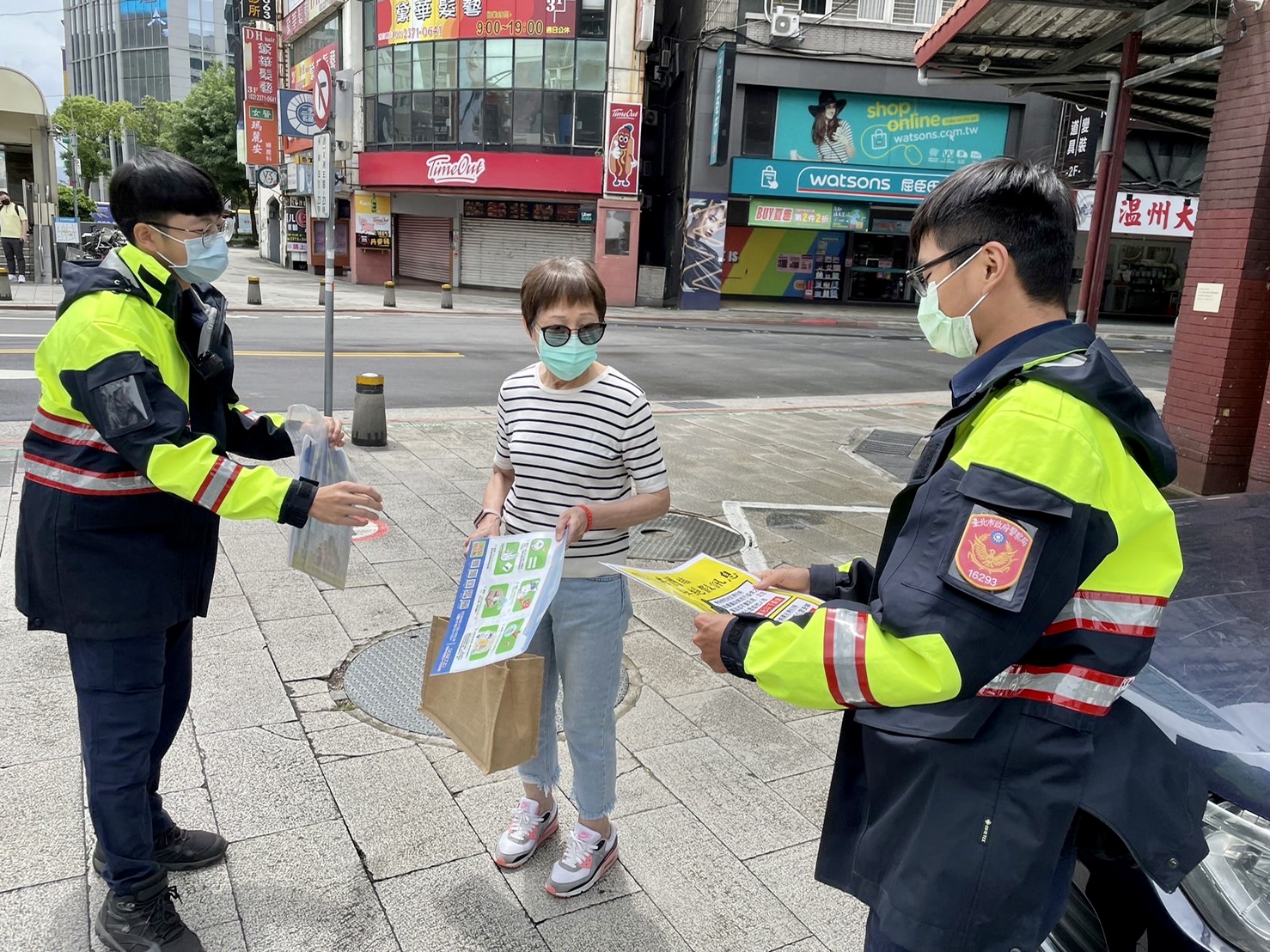 圖 臺北市保安警察大隊員警手持宣導海報，以標語提醒民眾，小心防疫期間常見的簡訊詐騙。