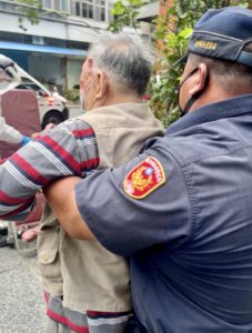 圖  臺北市保安警察大隊警員易法華立刻通報消防局派遣救護車到場救護，並協助攙扶傷者上救護擔架送醫診治。