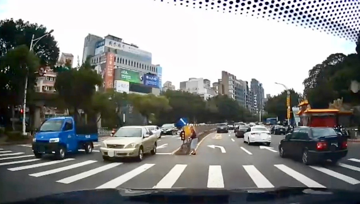 照片1-臺北市保大警巡邏發現一名行動不便拄著拐杖的老婦人，停留在車水馬龍的路中央險象環生、動彈不得。
