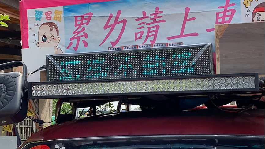 貨車司機自發性掛上「累ㄌ請上車」布條,幫忙載送走不動的香客。車頂跑馬燈的文案是司機從多次進香經驗中,體會出的自我感悟及警語。圖|齊偉先
